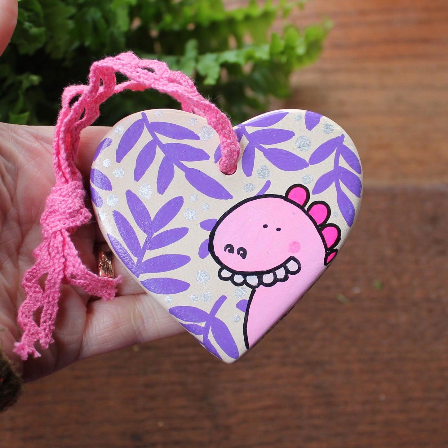 Goofy pink dinosaur heart hand painted by Laura Lee
