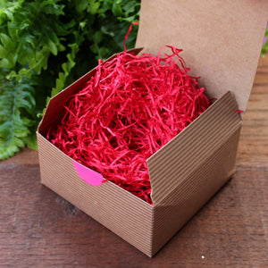 Kraft gift box filled with red paper shred