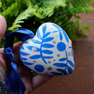 Blue ferns on a ceramic heart hand painted by Laura Lee 