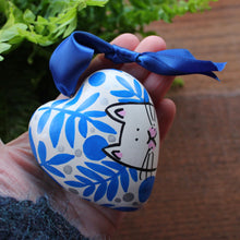 Load image into Gallery viewer, white cat surrounded by blue ferns and plants hand painted ceramic heart by Laura Lee Designs 