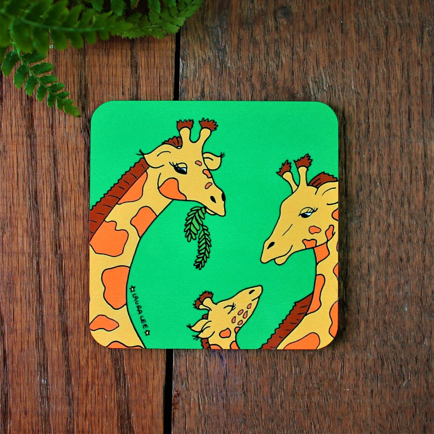 Bright green coaster with colourful giraffe in brown and yellow. Cork backed and heat proof. Laura Lee designs Cornwall.