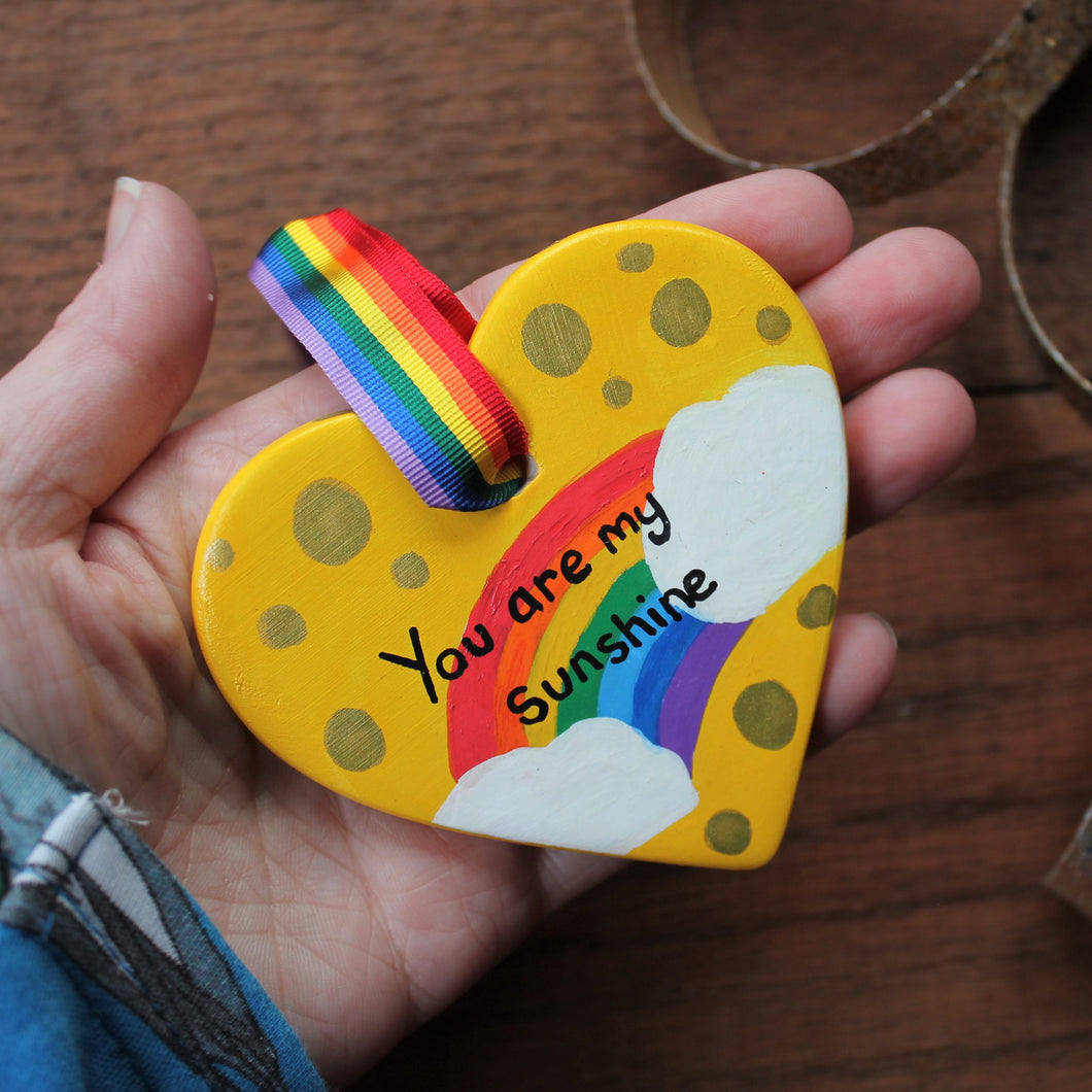 Hand painted yellow rainbow heart with clouds and gold spots 